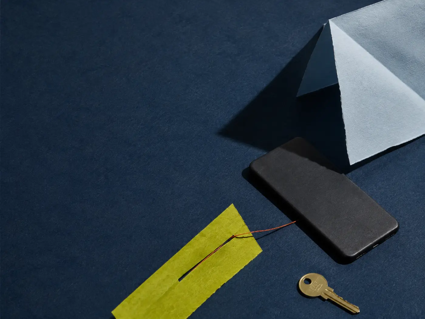 Telefon, klucz, nić i papierowa forma symbolizujące odpowiedzialność po podjęciu decyzji.