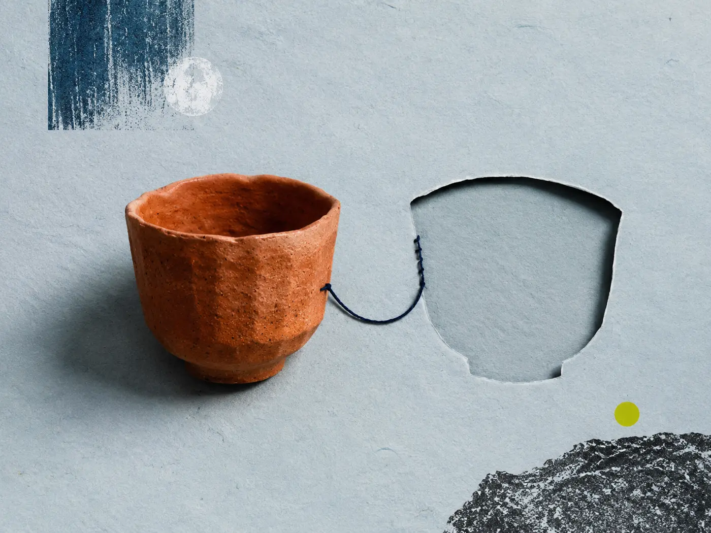 Ceramiczne naczynie i pusty wykrój w papierze symbolizujące wybrane oraz niewybrane życie.